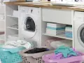 Lavandería moderna con lavadora y secadora. Cestas con ropa sucia y toallas dobladas, evocando la eficiencia de los detergentes años 60.