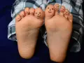 Caritas sonrientes en los dedos de bebés descalzos en invierno, jugando con sus pies.