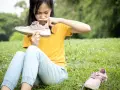 Niña con cara de asco huele un zapato, quizás por el sudor de los pies de niños tras un día de juegos.