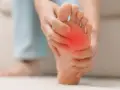 Persona se toca la almohadilla del pie, con una zona roja indicando dolor. Busca remedios caseros para el dolor en la almohadilla del pie.