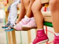 Niños con zapatillas deportivas rosas y grises. Un par de zapatillas rosas parece ser talla 4 zapatos.