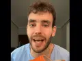 Hombre con bata azul muestra una zapatilla naranja, recordando que los pies crecen con la edad.