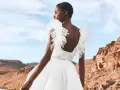 Novia con vestido blanco vaporoso, con volantes en los hombros, ideal para vestidos novia ibiza. Paisaje desértico al atardecer.