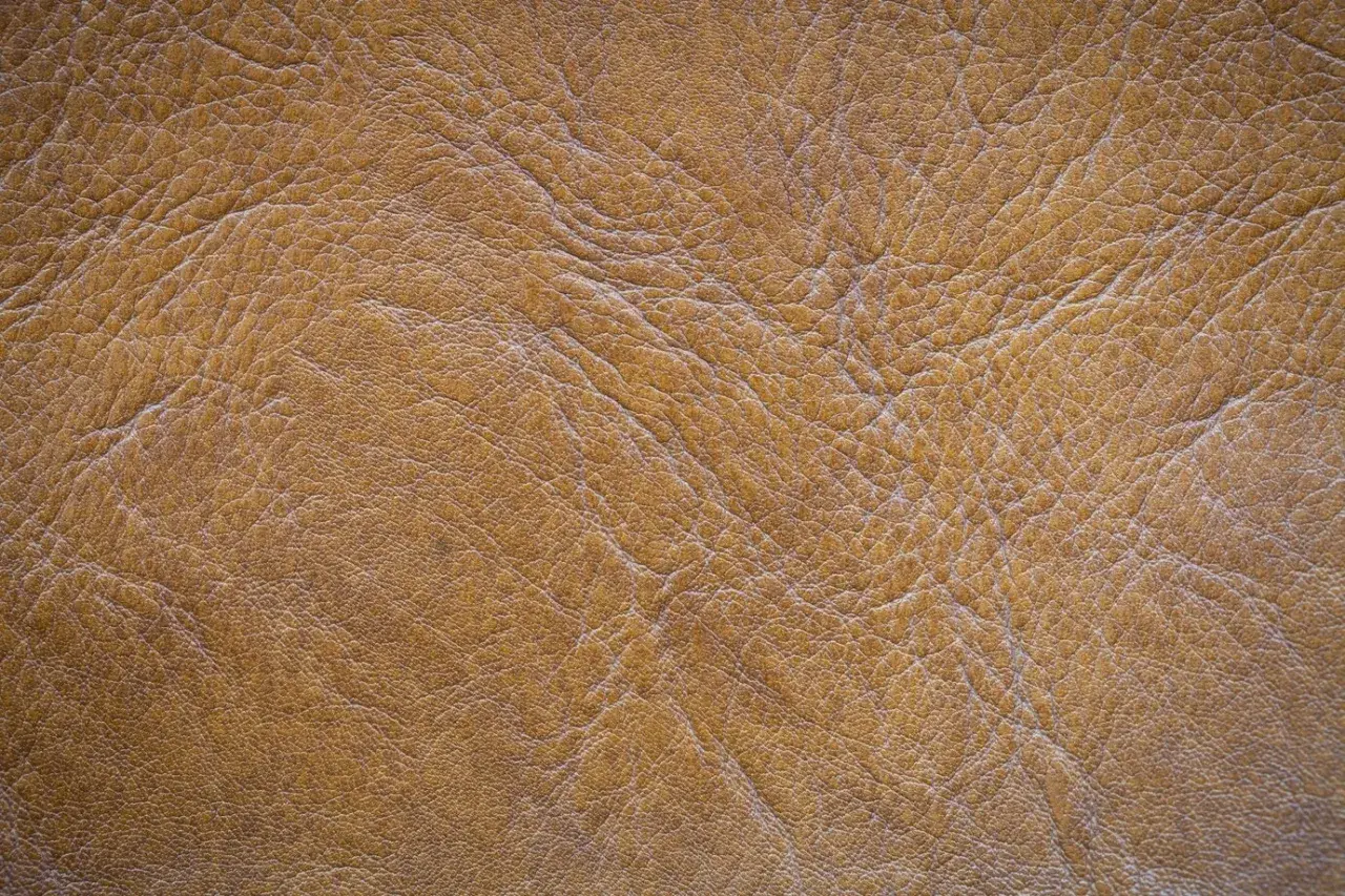 Textura de serraje marrón, que es un tipo de cuero con un acabado rugoso y natural, ideal para calzado o accesorios.