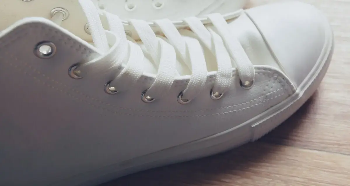 Primer plano de unas zapatillas blancas de tela, listas para limpiar y lucir impecables.