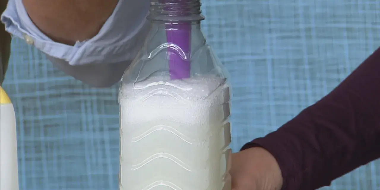 Vertiendo líquido en una botella para crear alternativas al suavizante.