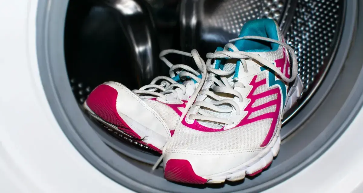 Zapatillas deportivas blancas con detalles fucsia y turquesa listas para aprender como lavar zapatillas en la lavadora.
