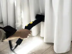 Limpieza profunda de cortinas blancas con vapor. El vaporizador elimina manchas y desinfecta, dejando las cortinas impecables.