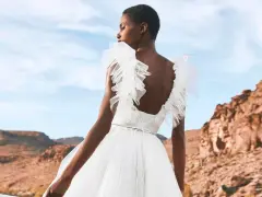 Novia con vestido blanco vaporoso, con volantes en los hombros, ideal para vestidos novia ibiza. Paisaje desértico al atardecer.