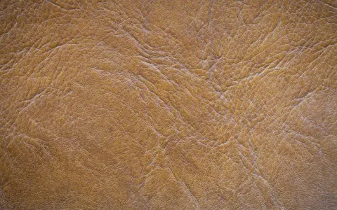 Textura de serraje marrón, que es un tipo de cuero con un acabado rugoso y natural, ideal para calzado o accesorios.