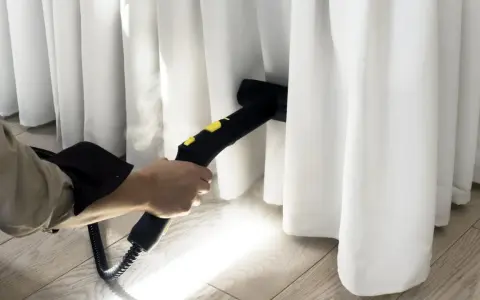 Limpieza profunda de cortinas blancas con vapor. El vaporizador elimina manchas y desinfecta, dejando las cortinas impecables.