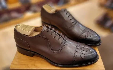 Elegantes zapatos de vestir marrones con puntera de cap toe y perforaciones. La talla UK se convierte a EU para un ajuste perfecto.