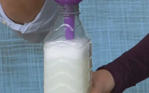 Vertiendo líquido en una botella para crear alternativas al suavizante.