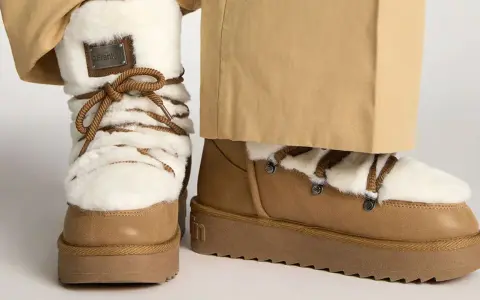 Botas de invierno marrones con forro de pelo blanco y cordones. Perfectas para limpiar y mantenerlas impecables.