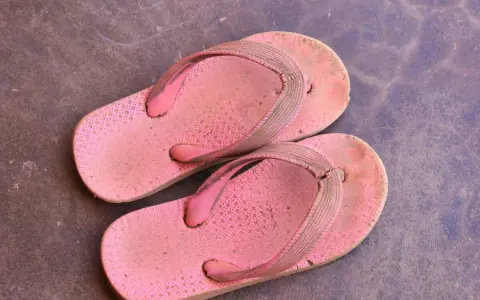 Chanclas de goma rosadas y sucias, listas para aprender como limpiar chanclas de goma y dejarlas como nuevas.