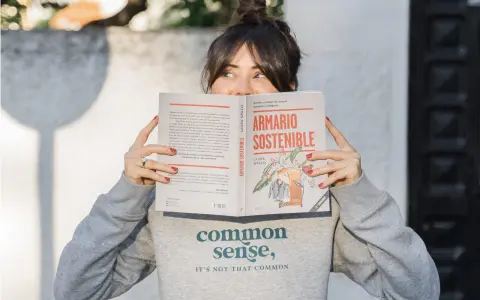 Mujer leyendo "Armario Sostenible", un libro sobre slow fashion España.