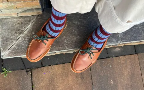 Mocasines de cuero marrón con cordones verdes y calcetines a rayas. Una idea de cómo combinar mocasines mujer para un look casual y chic.