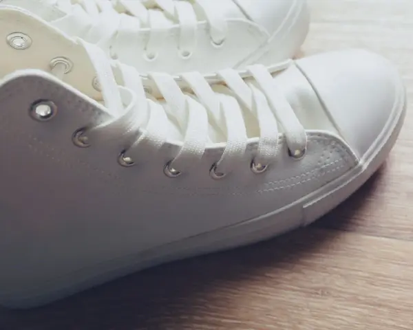 Primer plano de unas zapatillas blancas de tela, listas para limpiar y lucir impecables.