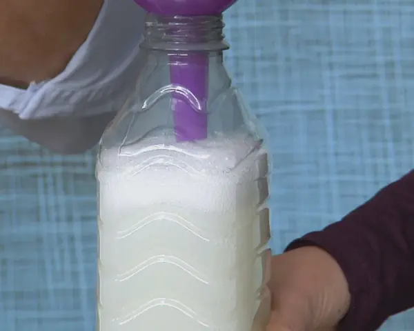 Vertiendo líquido en una botella para crear alternativas al suavizante.