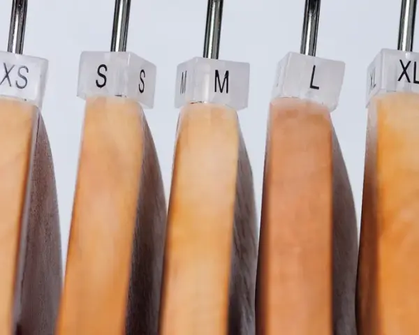 Perchas de madera con etiquetas de tallas XXS a XXL, mostrando la equivalencia talla europea y americana.