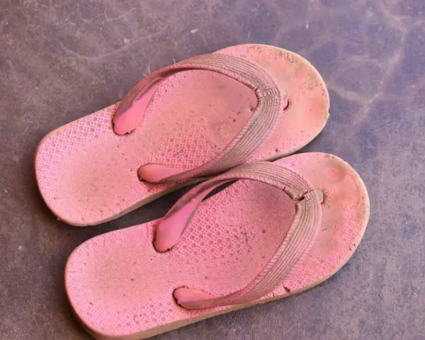Chanclas de goma rosadas y sucias, listas para aprender como limpiar chanclas de goma y dejarlas como nuevas.