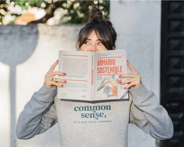 Mujer leyendo "Armario Sostenible", un libro sobre slow fashion España.