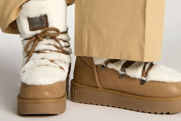 Botas de invierno marrones con forro de pelo blanco y cordones. Perfectas para limpiar y mantenerlas impecables.