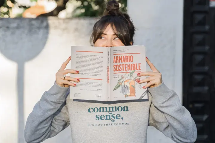 Mujer leyendo "Armario Sostenible", un libro sobre slow fashion España.