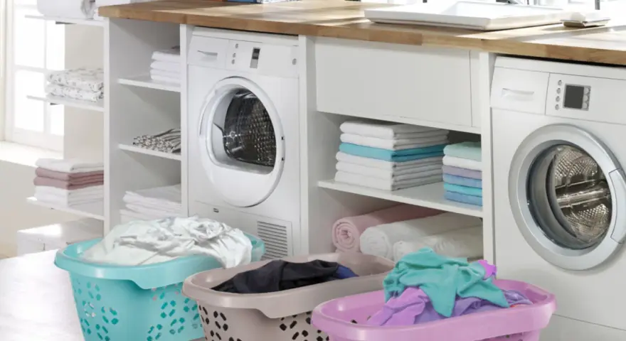 Lavandería moderna con lavadora y secadora. Cestas con ropa sucia y toallas dobladas, evocando la eficiencia de los detergentes años 60.
