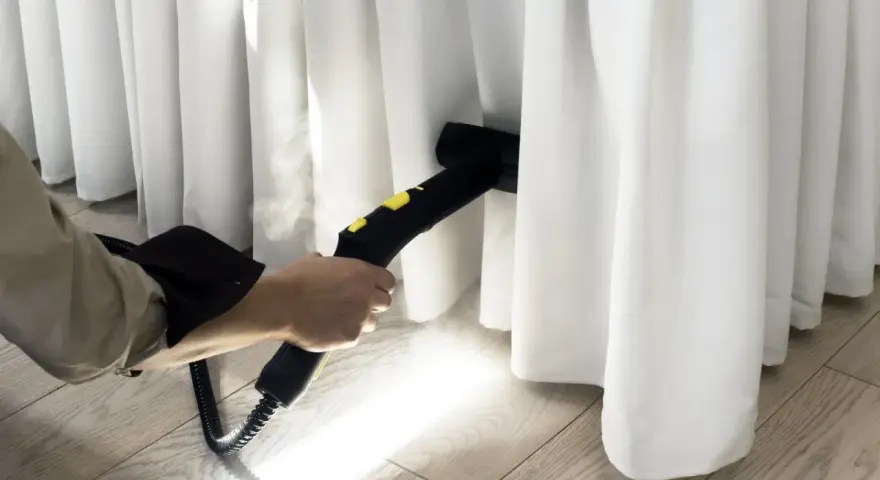 Limpieza profunda de cortinas blancas con vapor. El vaporizador elimina manchas y desinfecta, dejando las cortinas impecables.