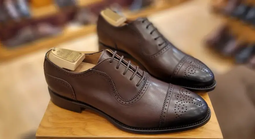 Elegantes zapatos de vestir marrones con puntera de cap toe y perforaciones. La talla UK se convierte a EU para un ajuste perfecto.
