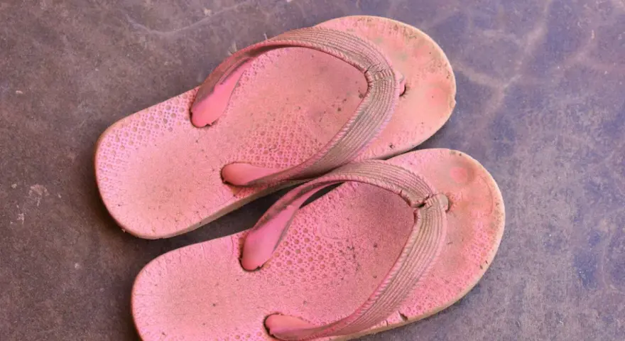 Chanclas de goma rosadas y sucias, listas para aprender como limpiar chanclas de goma y dejarlas como nuevas.