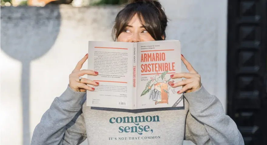 Mujer leyendo "Armario Sostenible", un libro sobre slow fashion España.