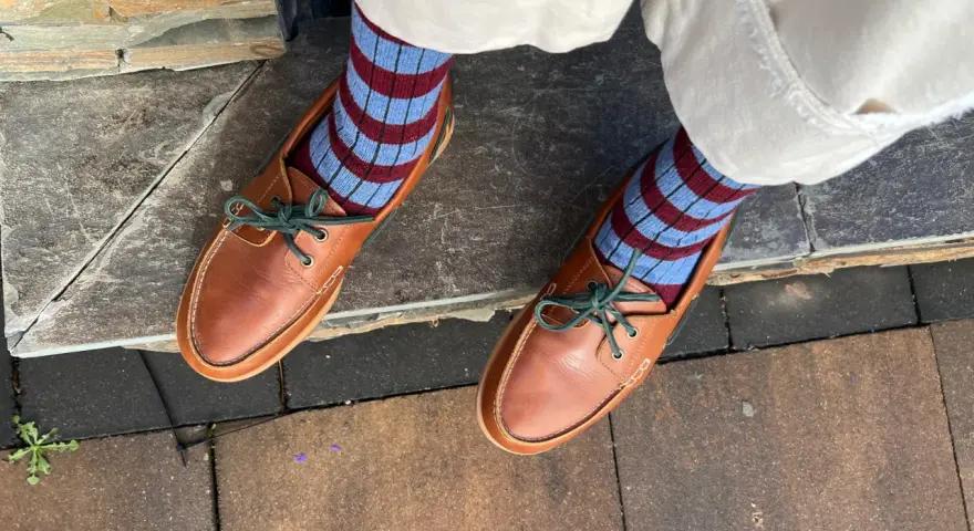 Mocasines de cuero marrón con cordones verdes y calcetines a rayas. Una idea de cómo combinar mocasines mujer para un look casual y chic.