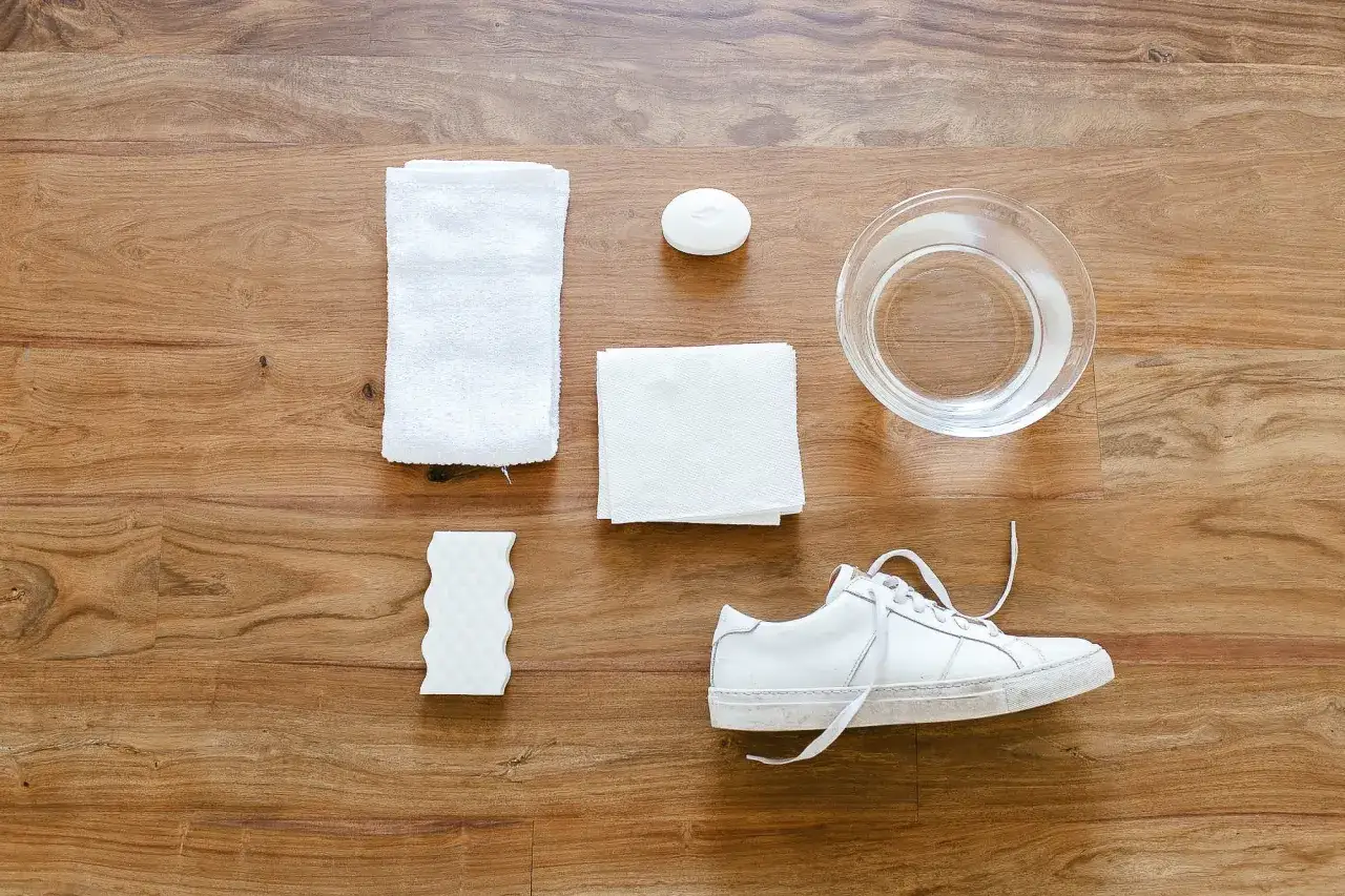 Kit para limpiar zapatillas blancas piel: jab&oacute;n, esponja, toallas, agua y un zapato.