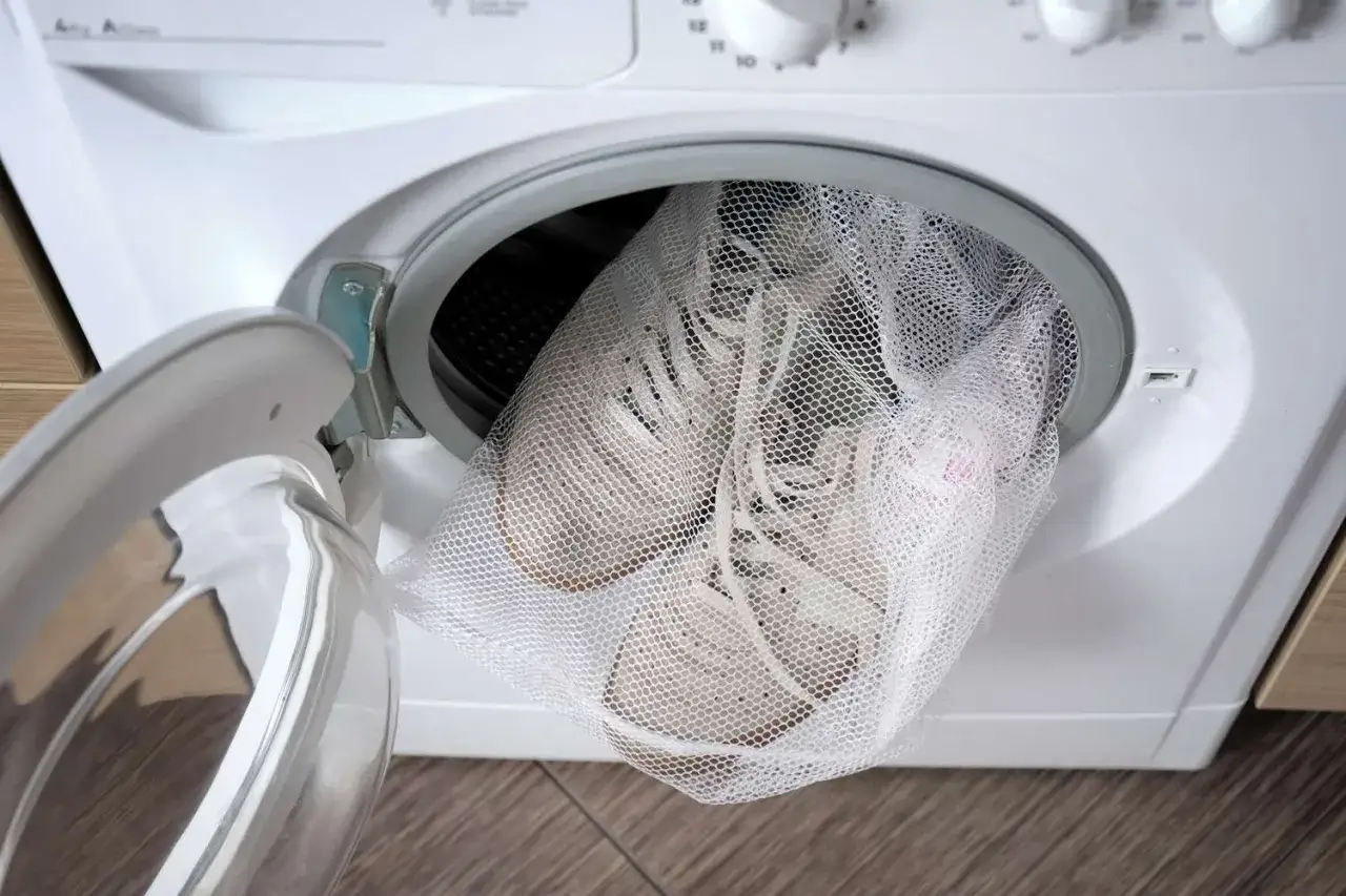Zapatillas blancas dentro de una bolsa de malla, listas para que se puedan lavar las Skechers en la lavadora.